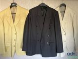 three suits hanging on a wall in a row