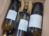 three bottles of wine in a box on a table