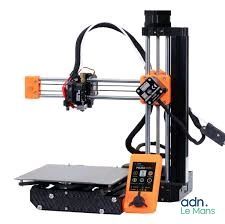 une image d'une imprimante 3D orange et noire posée sur une table