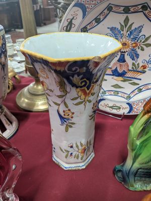 de nombreux vases et assiettes de toutes sortes sur la table
