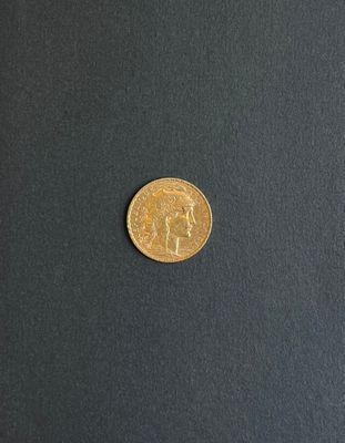 a close up of a gold coin on a black surface