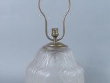 une image représentant une lampe en verre blanc munie d'une poignée en métal