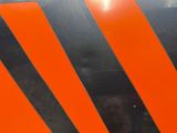 a close up of an orange and black stripe on the side of a truck