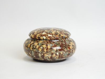 a small jar with a lid on a white surface