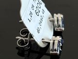 pair of silver and blue sapphire earrings with price tag on black surface