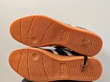 the soles of a pair of black and white shoes on top of a black box