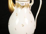 a white and gold coffee pot on a black background