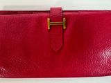 un portefeuille en cuir rouge muni d'un fermoir doré