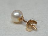 boucles d'oreilles à clous en forme de perle plaquées or sur un fond blanc