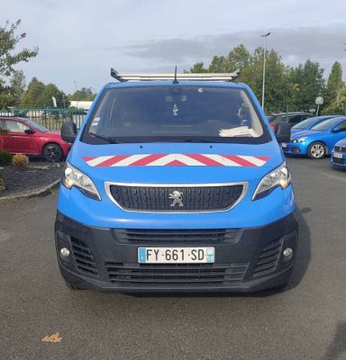 une petite camionnette bleue garée sur un parking