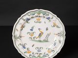 a white plate with a bird and flowers on it