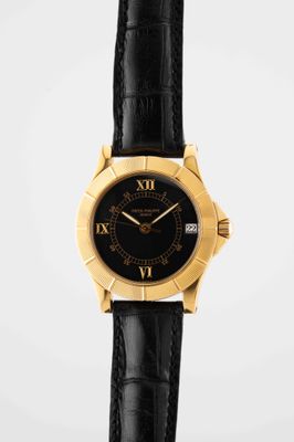 a close up of a black and gold wrist watch with roman numerals