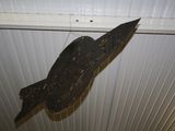 a wooden bird hanging from the ceiling of a room