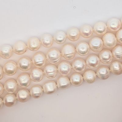 des perles sont disposées en rangée sur une surface blanche