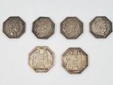 six different types of coins on a white surface