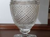 un vase en verre posé sur une table en bois à côté d'un miroir