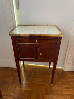 une petite table avec un plateau en marbre posée sur un parquet en bois massif