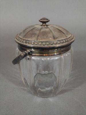 a glass jar with a silver lid on a table