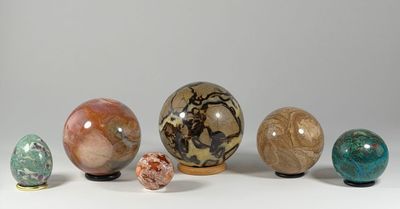 five different colored marbles sitting on a white surface