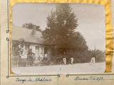 a black and white photo of a group of people in front of a house