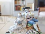 a figurine of a man and woman sitting on top of a table