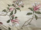 a close up of a bed with a floral design on it