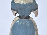 a blue and white figurine of a woman with a bird on her head