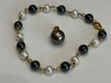 un gros plan sur un bracelet orné d'une perle noire et blanche