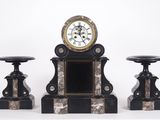 une horloge posée sur une table, à côté de deux tabourets