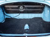 a trunk of a blue car with a black floor mat