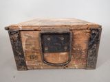 an old wooden box with a metal handle on a table