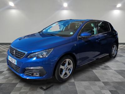 a blue car parked in a garage with a checkered floor