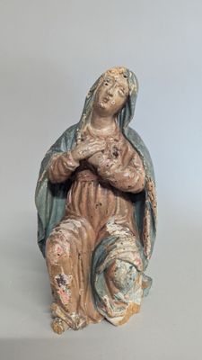 statue of a woman sitting on a chair with her arms crossed