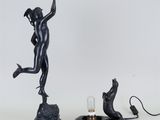 une image représentant une statue de femme tenant une lampe à côté d'un chat