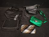 several purses are lined up on a black surface, including a purse, a handbag, and a purse