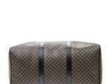 a brown and black duffel bag sitting on top of a white surface
