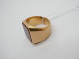 un gros plan d'une bague en or sertie d'une pierre marron