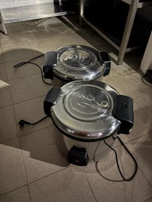 deux friteuses électriques posées par terre dans la cuisine