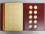 an open book with a picture of a set of coins inside of it