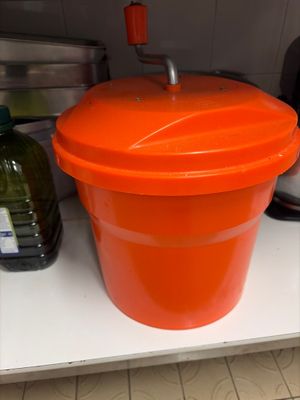 an orange bucket sitting on a shelf in a kitchen