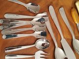 a lot of spoons and spoon knives on the table