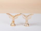 pair of gold angel figurines on a white surface