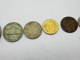five different types of coins in a row on a white surface