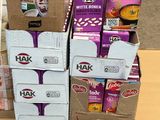 Plusieurs cartons de nourriture sont empilés sur une palette dans un magasin