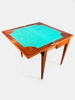 Une table à jeu en placage de bois à plateau pliant ouvrant …