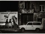 black and white photograph of a car parked on the side of the road