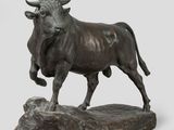 statue of a bull standing on a rock on a white background