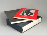 three books stacked on top of each other on a white surface