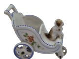 porcelain figurine of a baby carriage with a cat in it