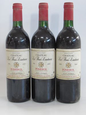 three bottles of red wine sitting next to each other on a white surface